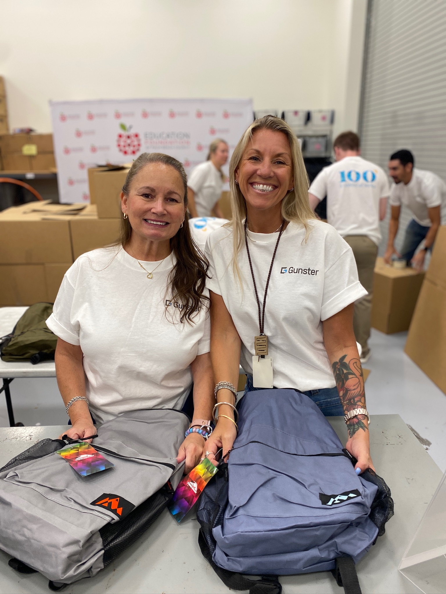 Gunster Team Members Holding Backpacks, Vicki Schuster and Karen McClelland